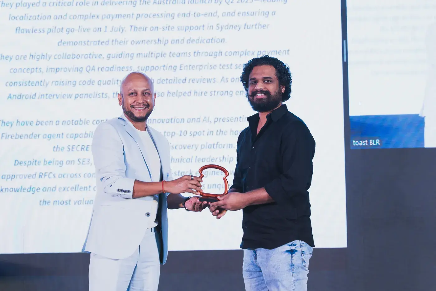 A recipient shaking hands as they take their award on stage