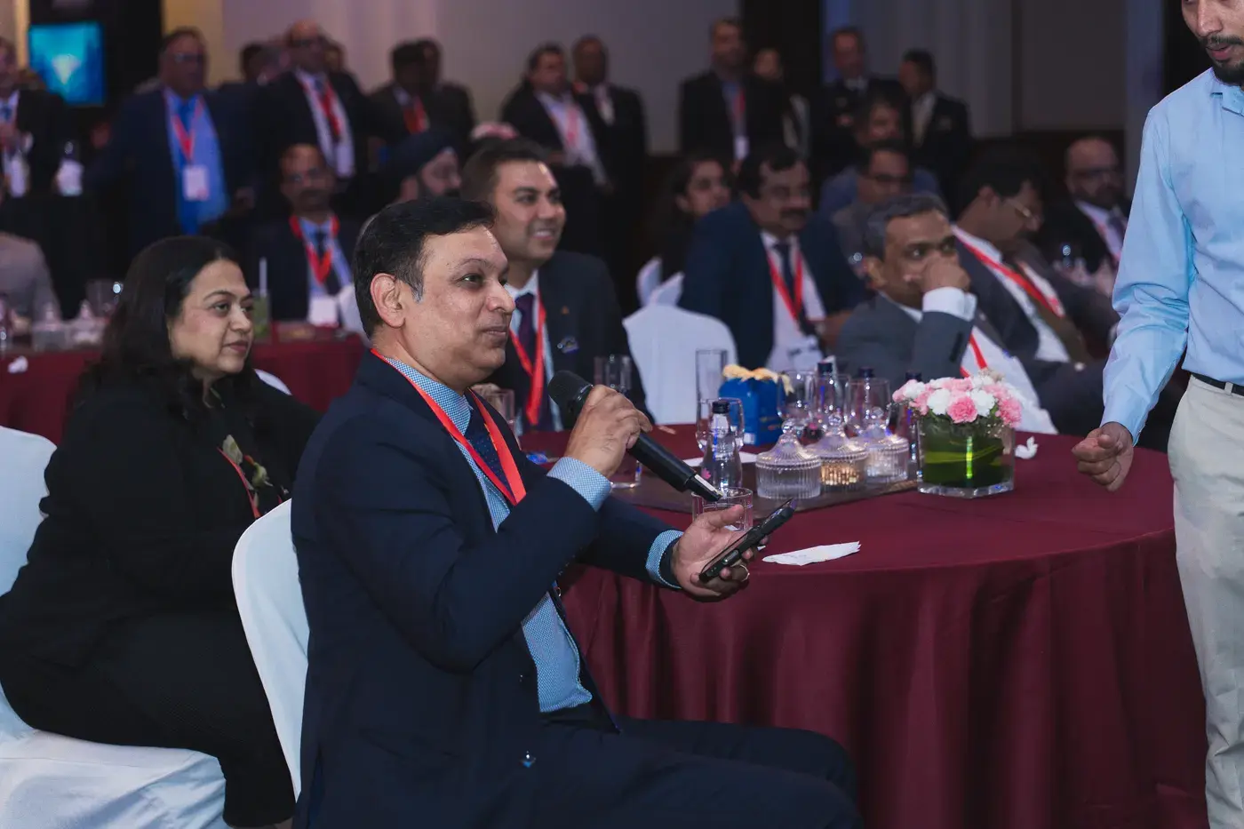 A delegate putting a question to the panel from the floor of a conference hall